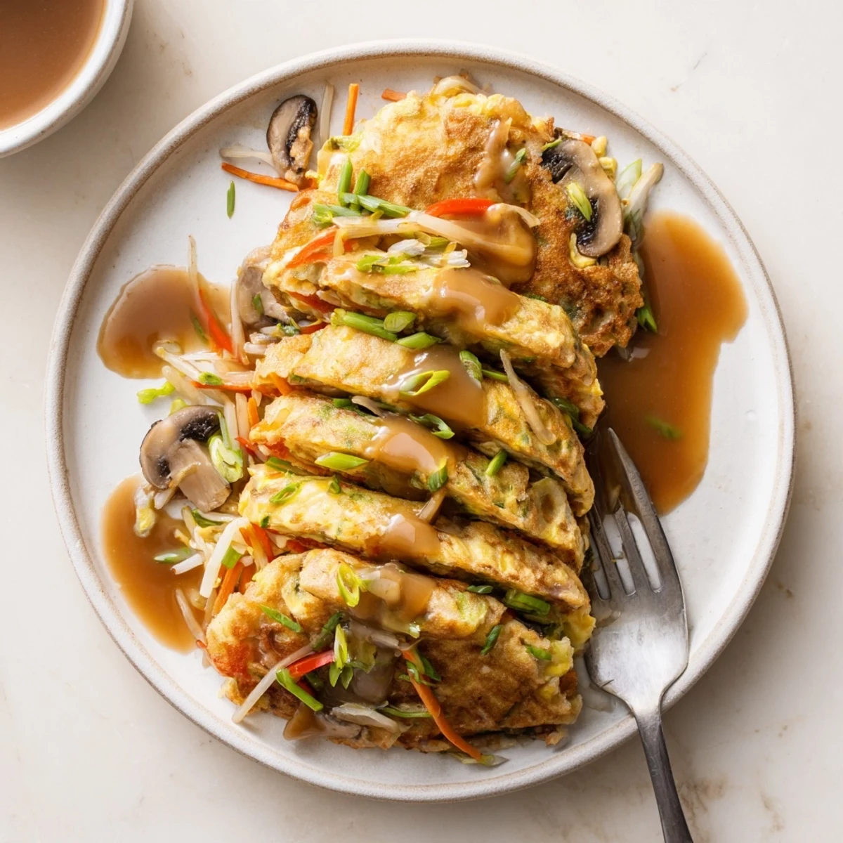 Fluffy vegetable-packed Egg Foo Young omelets fried until golden and drizzled with thick sauce