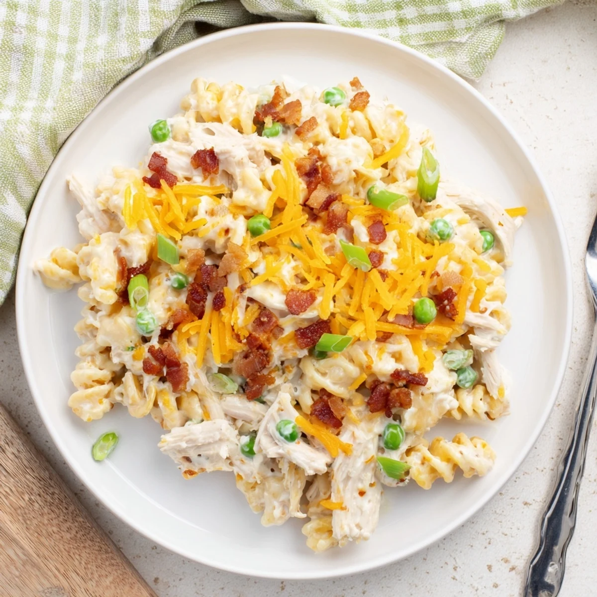 Serving of cheesy Crack Chicken Casserole garnished with green onions and savory bacon crumbles