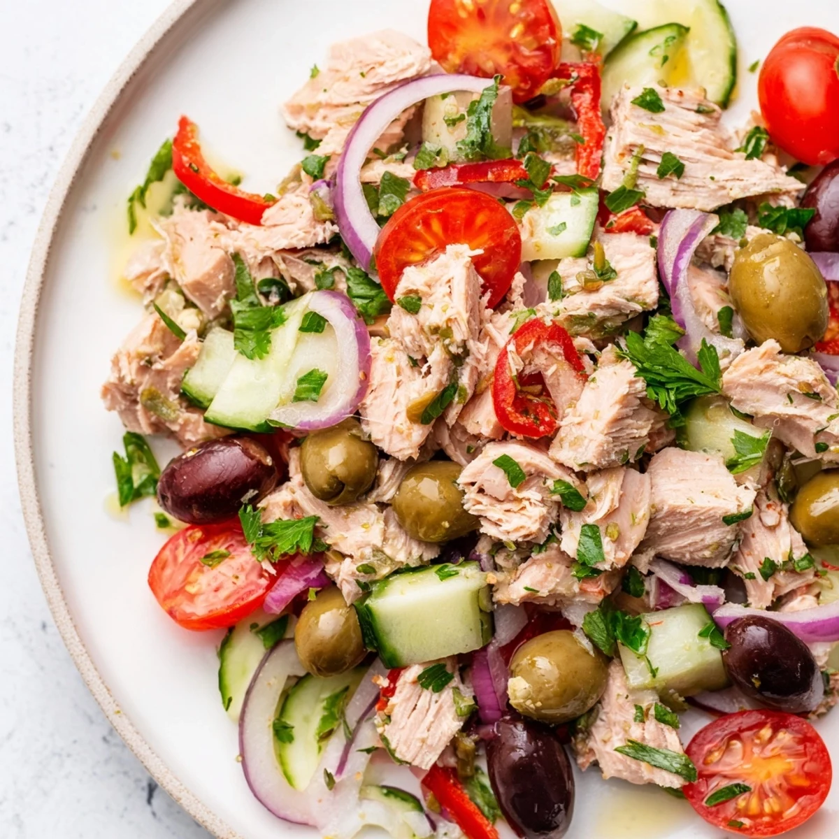 Bright Mediterranean Tuna Salad featuring flaked tuna, crisp vegetables, and Kalamata olives drizzled with lemon dressing