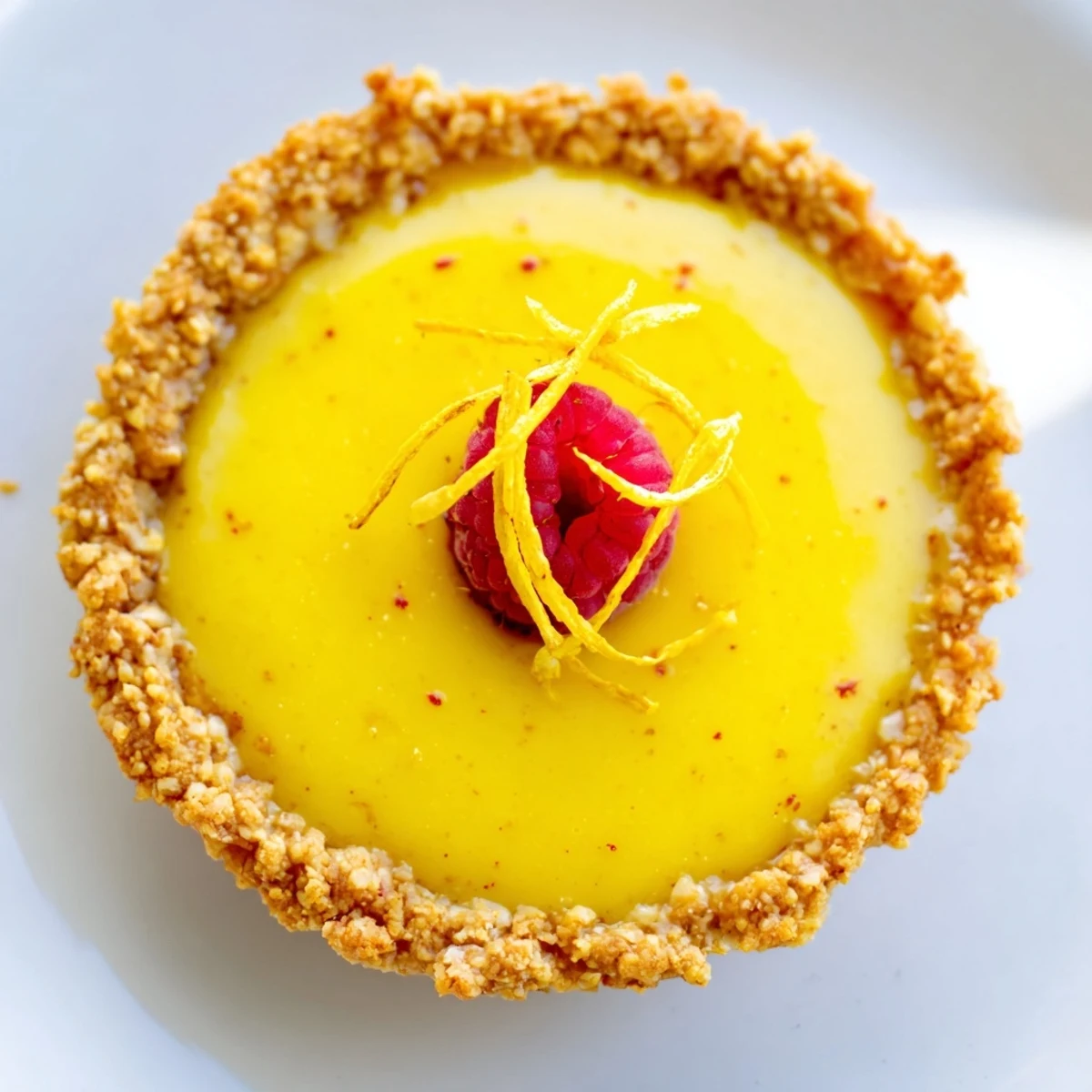 Mini vegan lemon tarts with silky custard filling in golden almond crusts topped with fresh berries