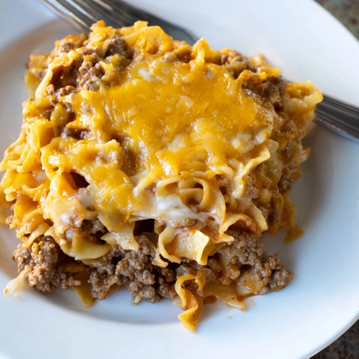 Hearty Beef Lombardi Casserole layered with noodles and tangy tomatoes, family-style