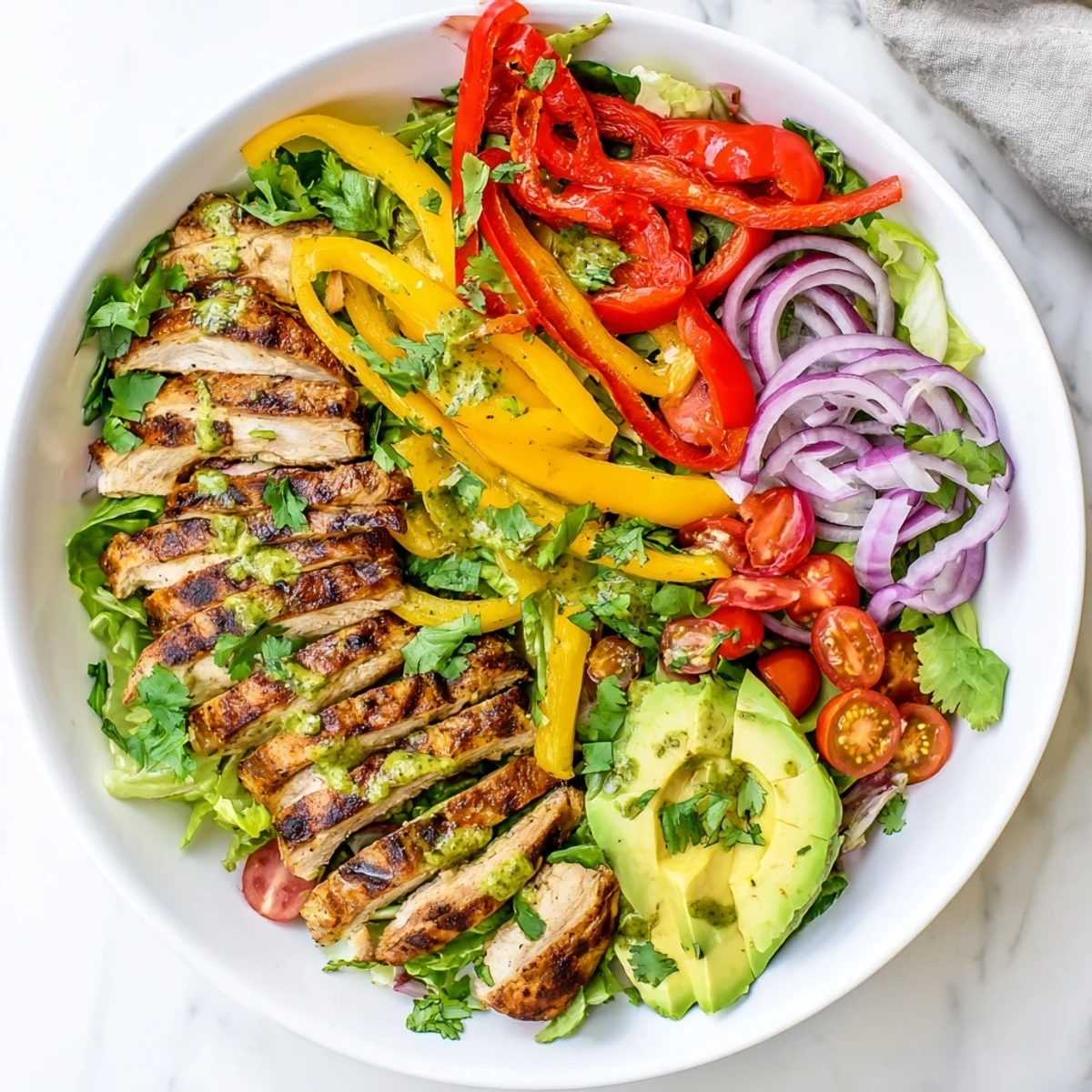 Healthy Tex-Mex style salad featuring juicy grilled chicken breast strips with colorful vegetables and creamy avocado