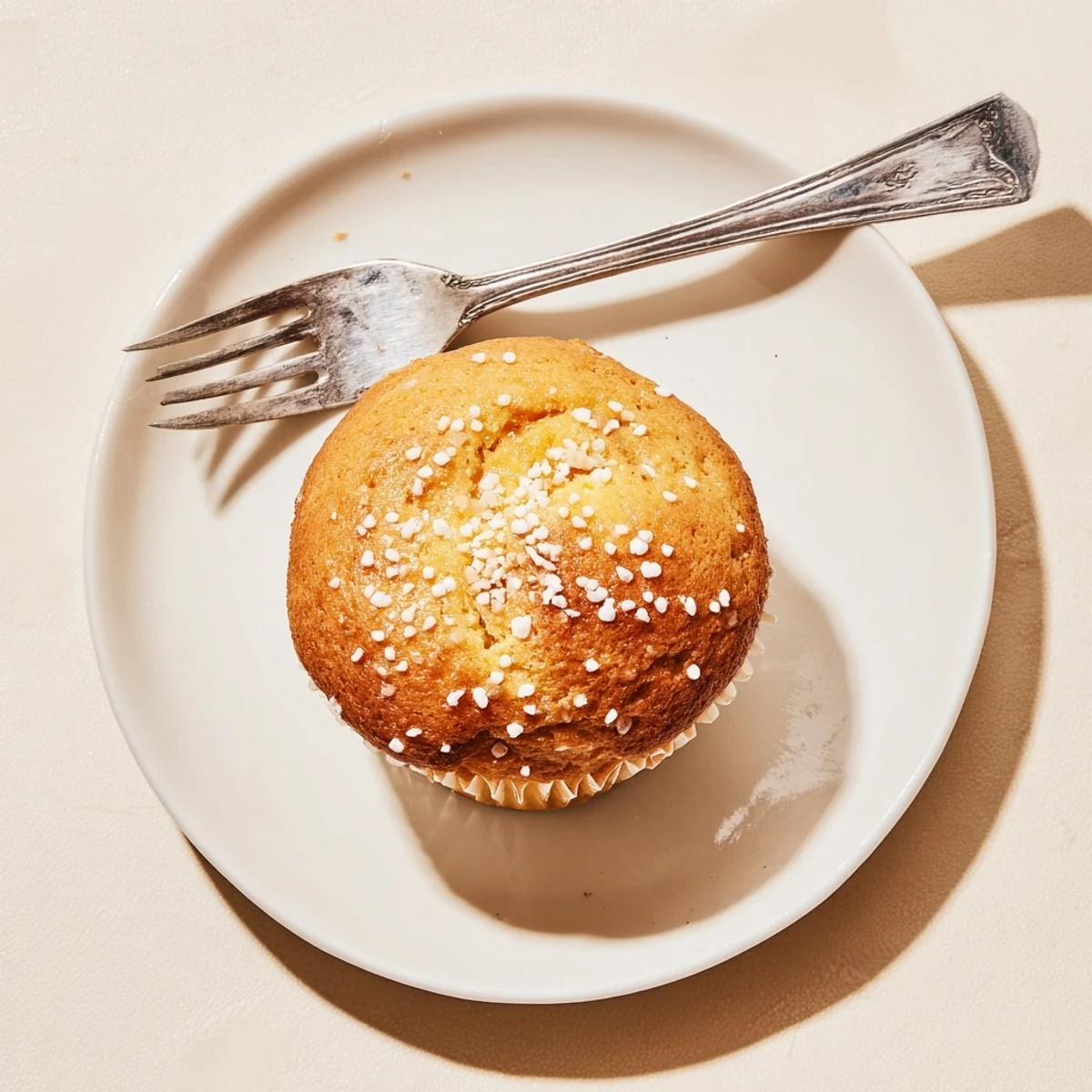 Golden lemon cream cheese muffins with coarse sugar topping on a wire rack