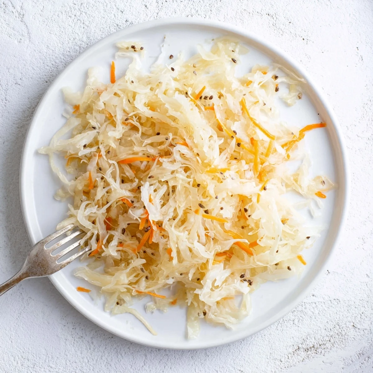 Golden fermented sauerkraut packed in glass jar with tangy brine and fresh green cabbage strands