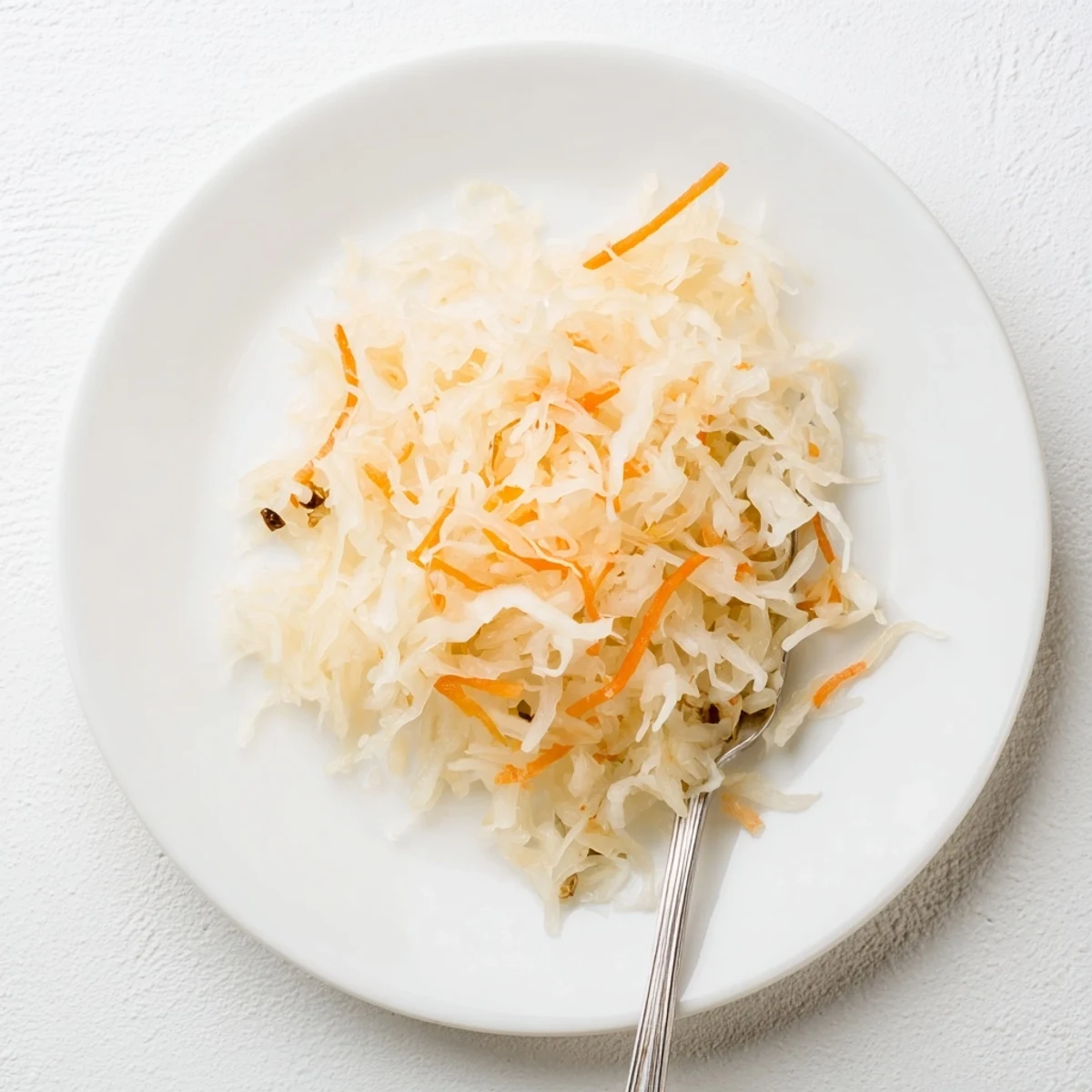Hearty German sauerkraut condiment served in rustic crock with pale yellow fermented cabbage and brine