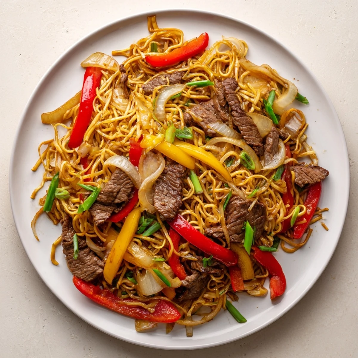 Beef chow mein with colorful peppers and onions in a savory stir-fry