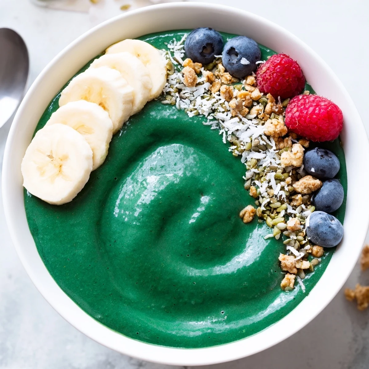 Green Smoothie Bowl With Spirulina, Banana & Hemp Seeds topped with crunchy granola