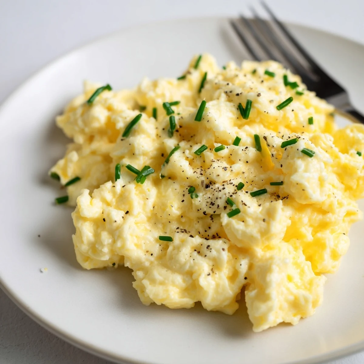 Plate of Cottage Cheese Scrambled Eggs With Chives nestled beside smoked salmon slices