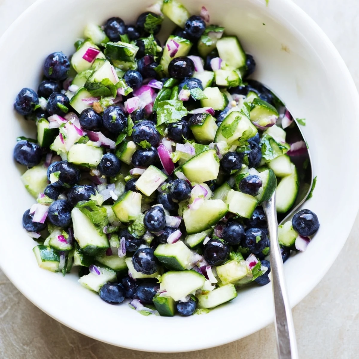 Blueberry cucumber salsa in a bowl with tortilla chips for dipping