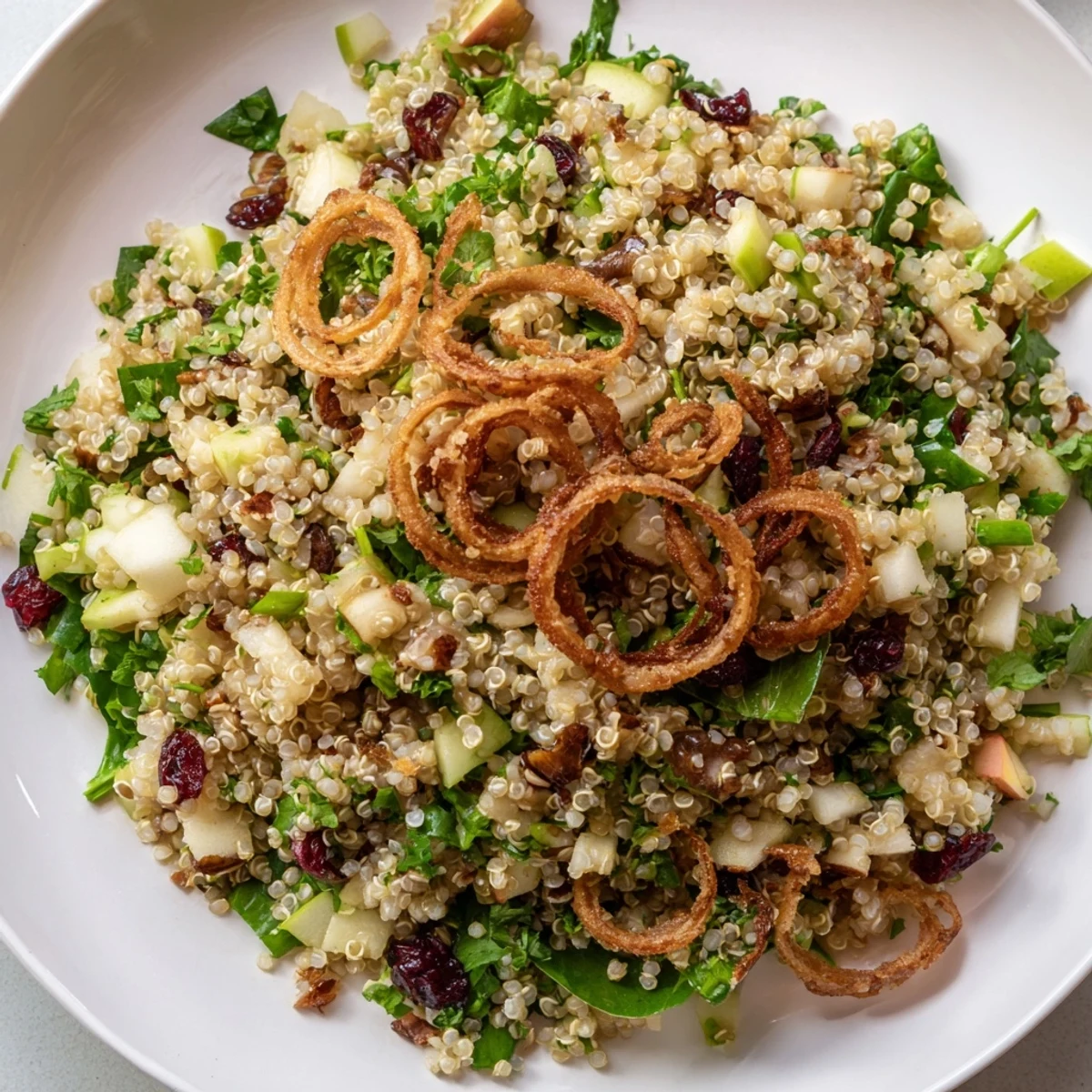 Golden crispy shallots crown this vibrant honey mustard quinoa apple salad in a wooden bowl