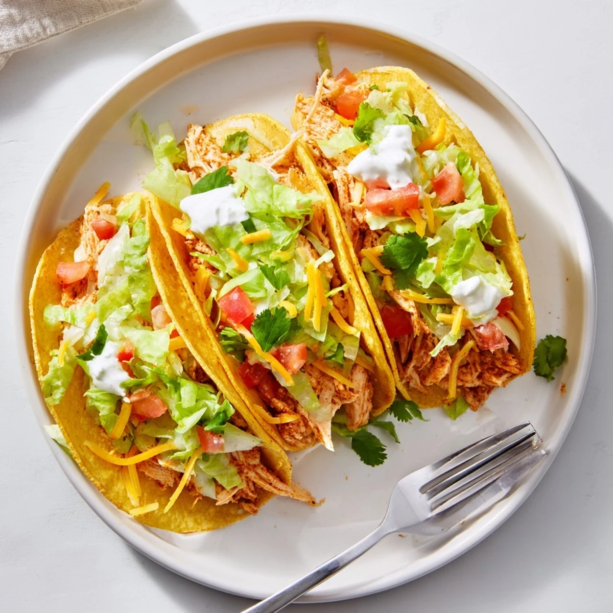Juicy slow cooker ranch chicken tacos topped with melted cheese and fresh cilantro