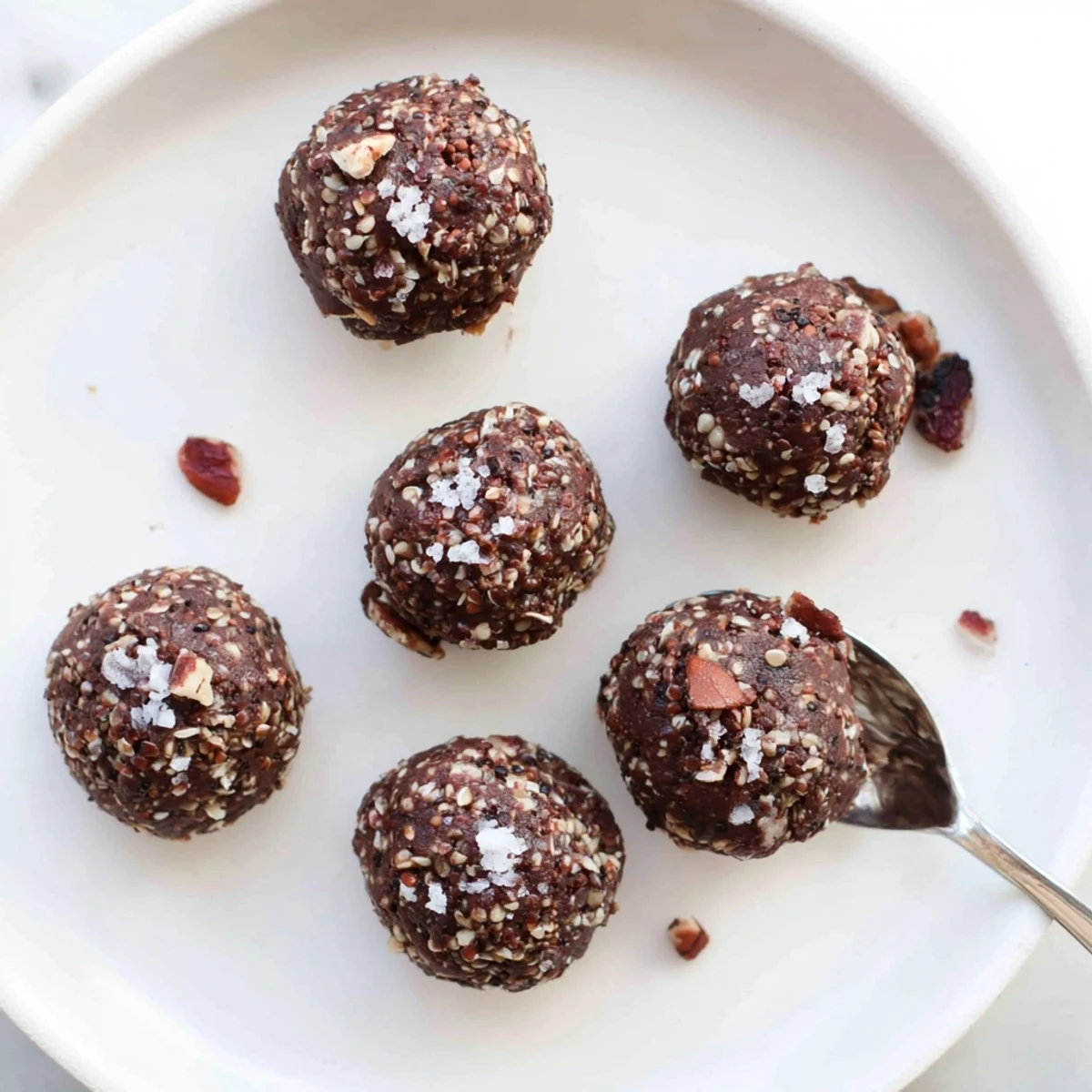 Chocolate quinoa crunch bites nestled in parchment paper with coconut and oat clusters visible