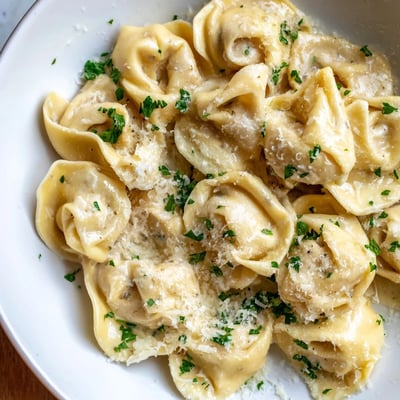 Plump handmade chicken tortellini swimming in a rich buttery cream sauce with parsley